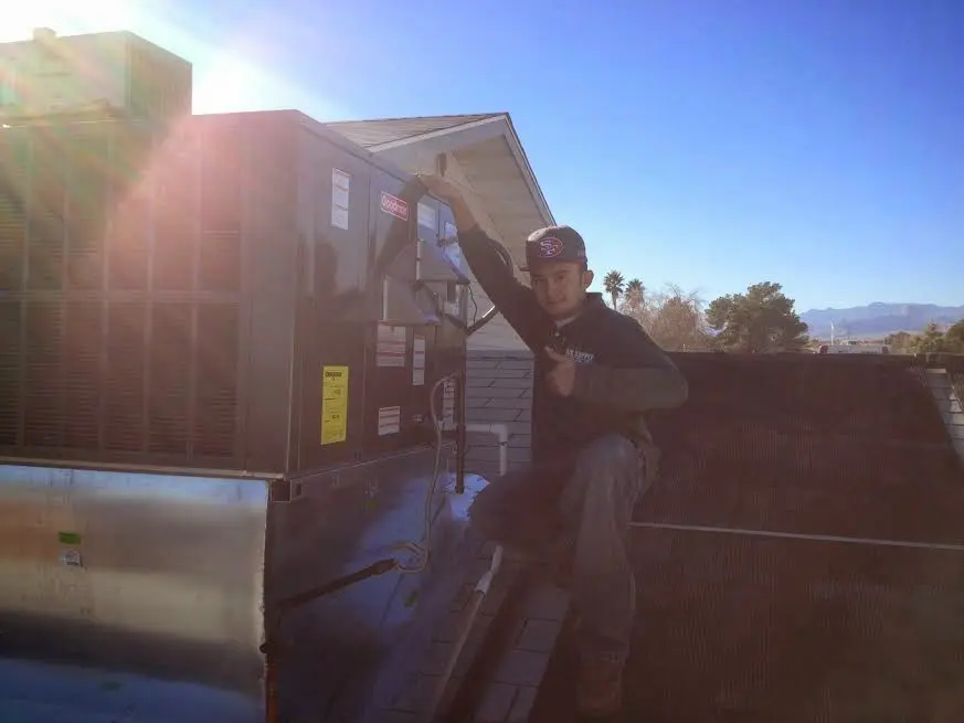 HVAC technician performing HVAC Inspection on a rooftop unit in Chelsea